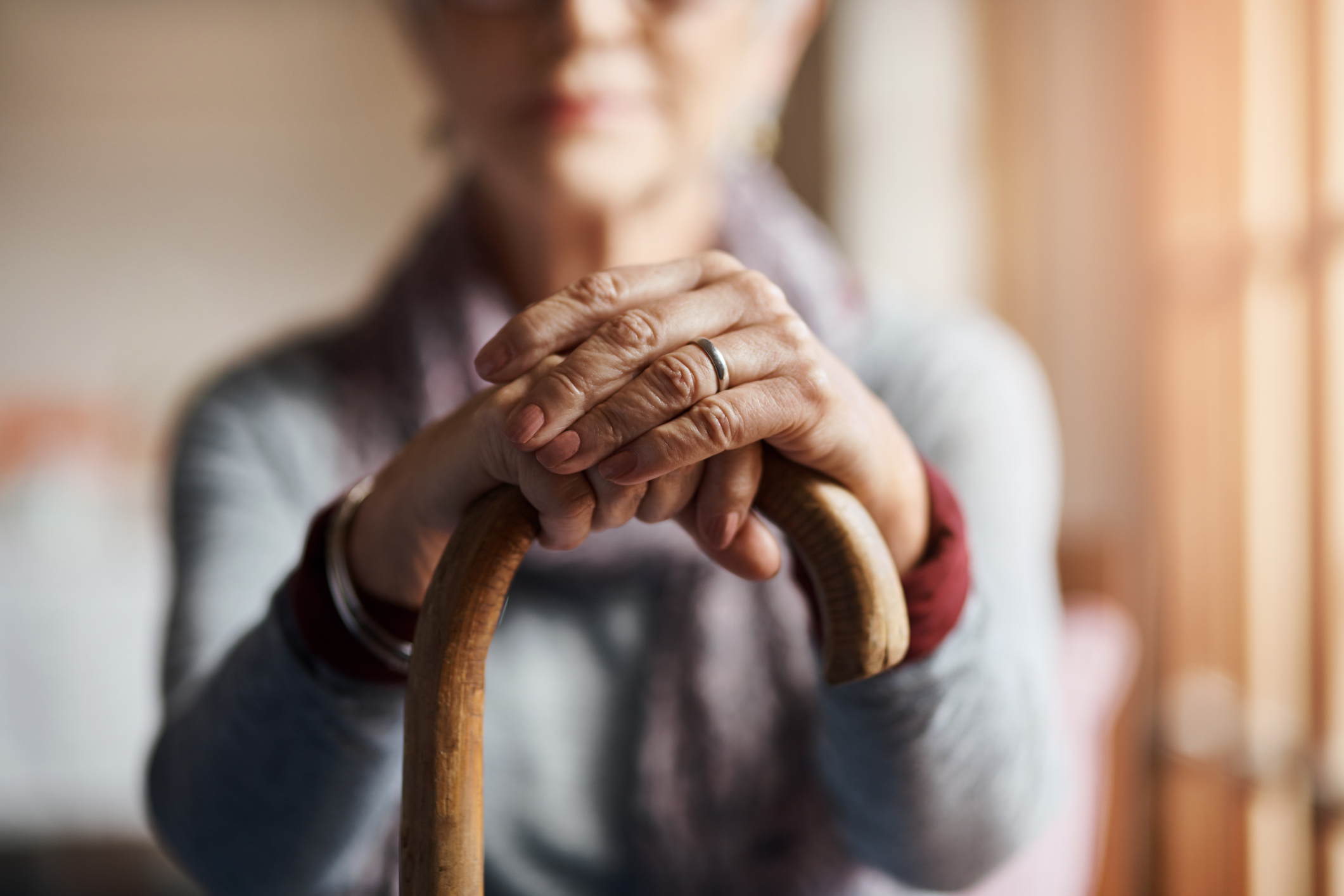 An image of a caregiver talking with two elderly residents as they work on arts and crafts